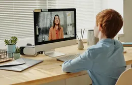 Ein Kind sitzt am Tisch und schaut auf den iMac. Was der Europäische Barrierefreiheitsgesetz für E-Learning bedeutet.